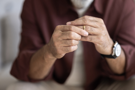 A man fidgets with his wedding ring, contemplating divorce